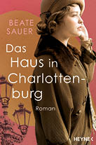 Frau mit hochgesteckten Haaren und braunem Mantel vor rotem Hintergrund mit Stra enlaternen, daneben der Schriftzug 'Beate Sauer Das Haus in Charlottenburg Roman HEYNE'.