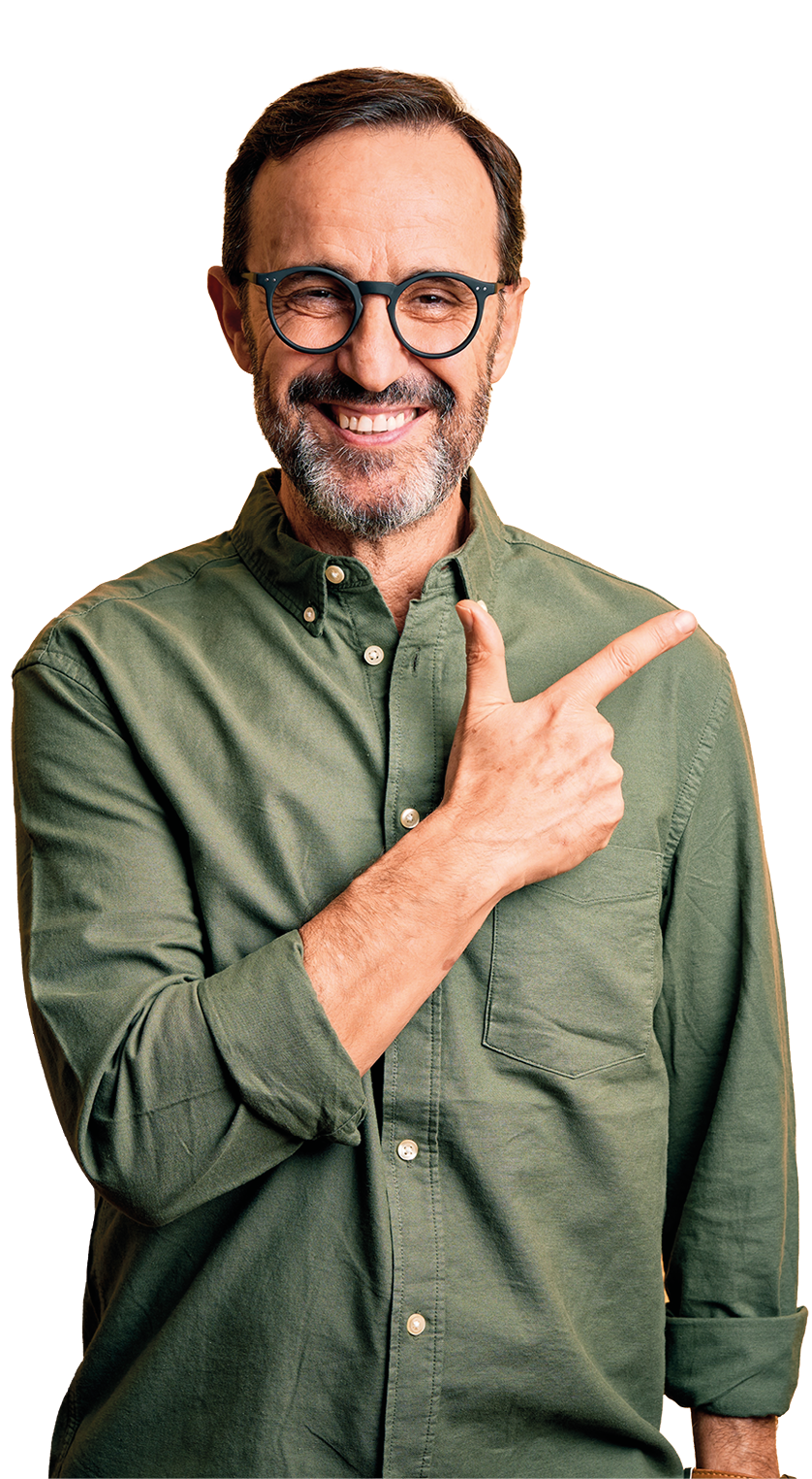 Middle age hoary man wearing casual green shirt and glasses over isolated yellow background cheerful with a smile of face pointing with hand and finger up to the side with happy and natural expression on face