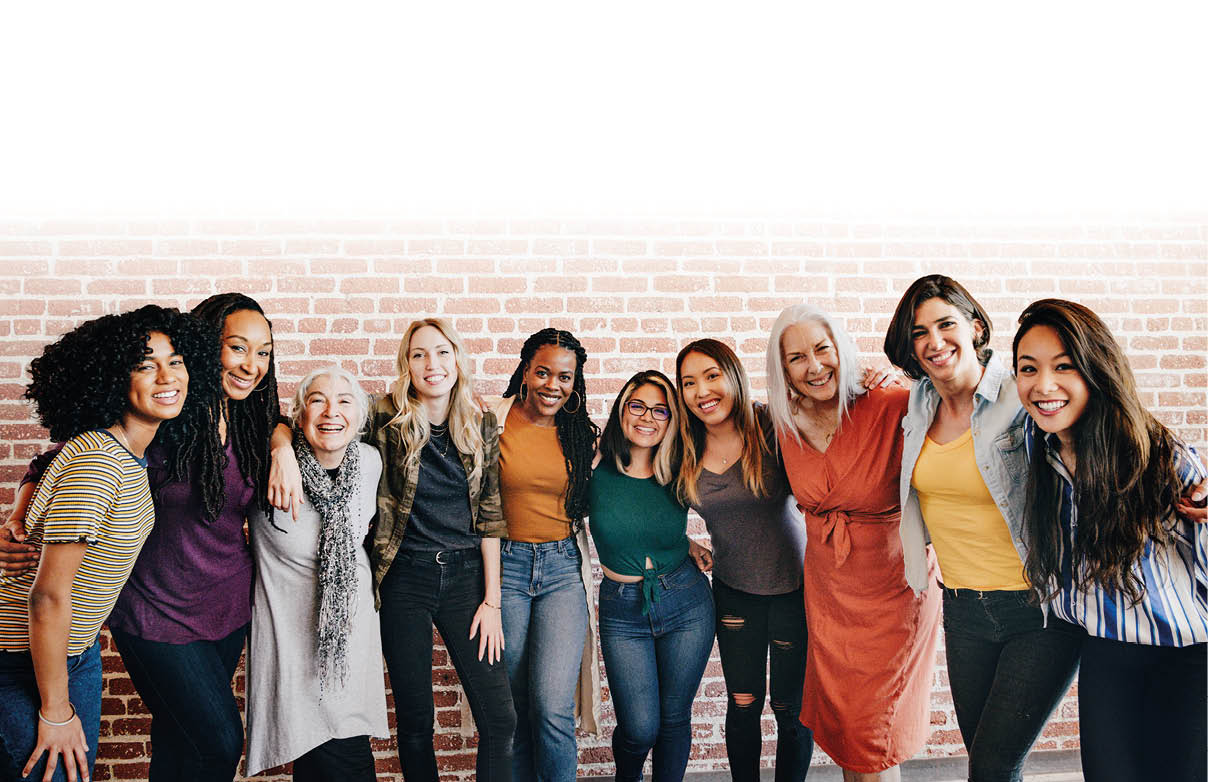 Cheerful diverse women standing in front of a red brick wall