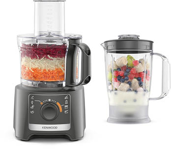 Ein moderner K chenmaschine mit verschiedenen Aufs tzen zeigt geraspeltes Gem se im Hauptbeh lter und einen Mixer mit Fr chten und Milch daneben, darunter sind Zubeh rteile f r unterschiedliche Schneid- und Raspelfunktionen angeordnet. Beschreibung von KI generiert
