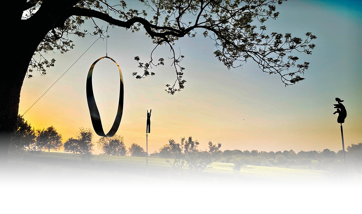 Ein gro er Baum mit einem h ngenden Ring und zwei Stangen steht vor einer gr nen Landschaft bei Sonnenuntergang. Beschreibung von KI generiert